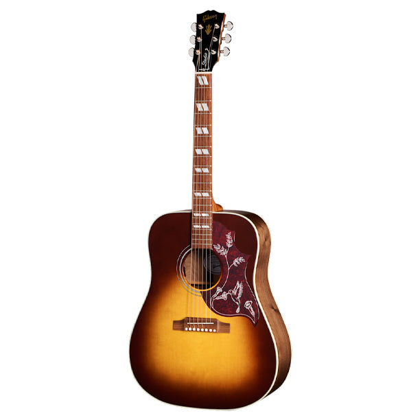 Gibson Hummingbird Studio Walnut with gloss nitrocellulose-finished Sitka spruce top, Walnut Burst finish. Square-shoulder body handcrafted in Bozeman. Gloss nitro Sitka spruce top, satin-finished walnut back and sides. Full-depth body. Advanced Response utile neck, compound dovetail joint, 24.75 in. scale. Rosewood fretboard with MOP crown inlays, 20 frets. TUSQ hardware. Grover Rotomatic tuners. LR Baggs Element Bronze active under-saddle pickup. Modern hardshell case included.